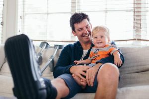 injured man with income protection smiling holding happy child